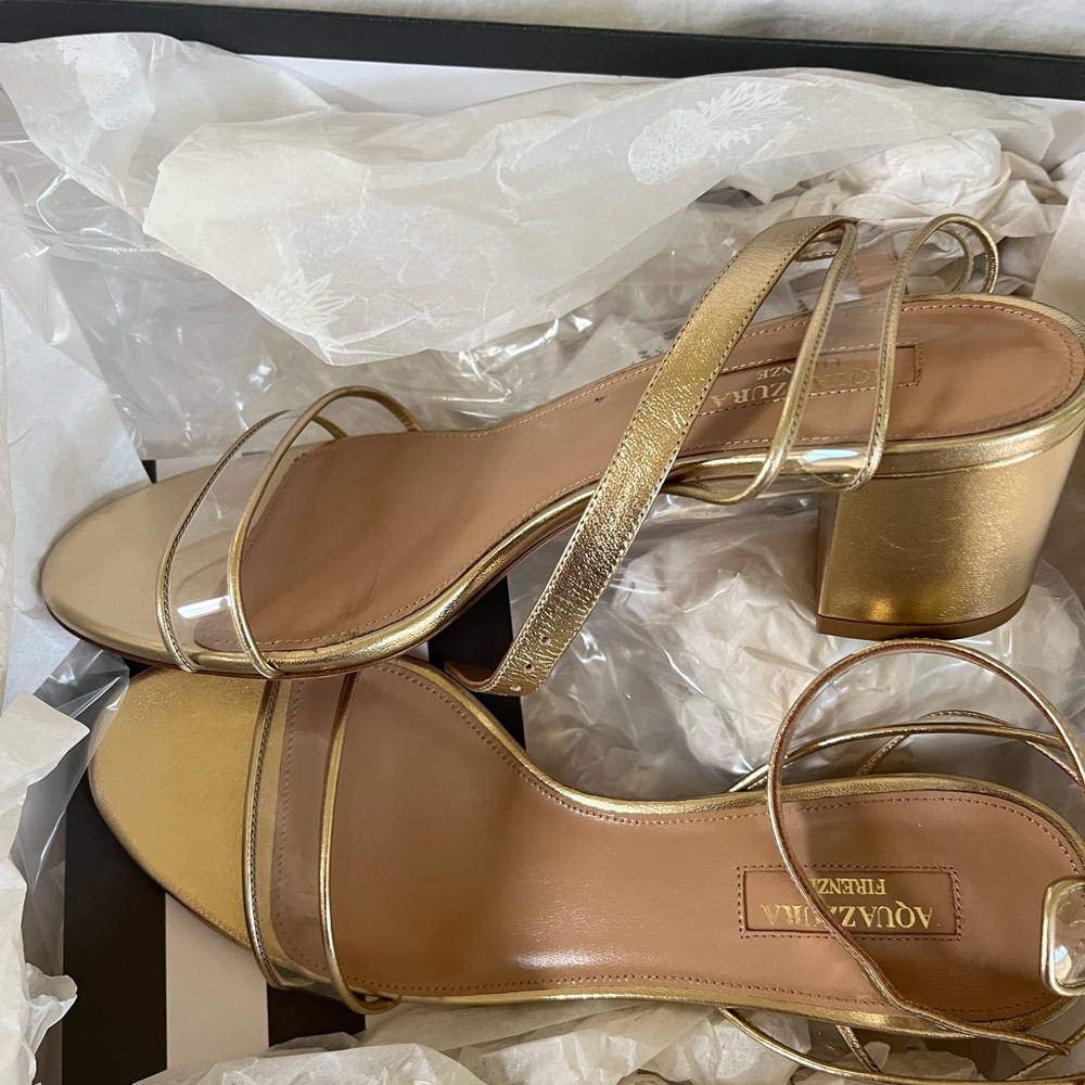 New in original box, gold Aquazurra heels with low heel, clear tie portion